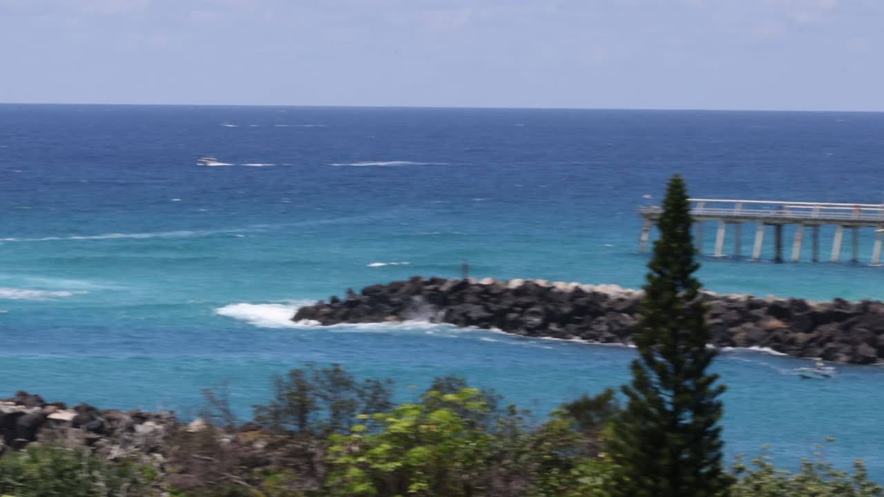 Ocean views with sailboats, jetty, and lush greenery