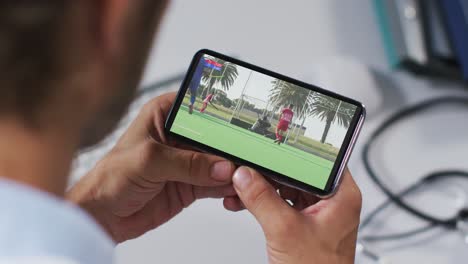 Composite-of-male-doctor-watching-hockey-match-on-smartphone