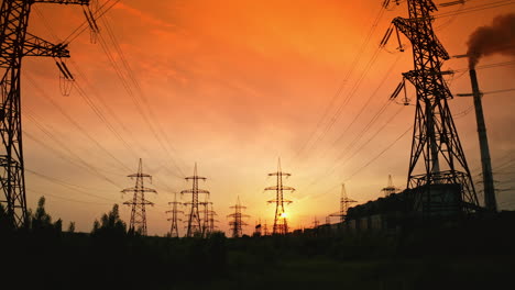 transmission lines under red evening sky. high-voltage electric towers with wires in nature at beautiful sunset. power lines against the backdrop of setting sun.