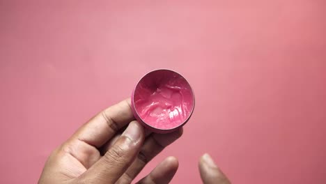 applying pink lip balm