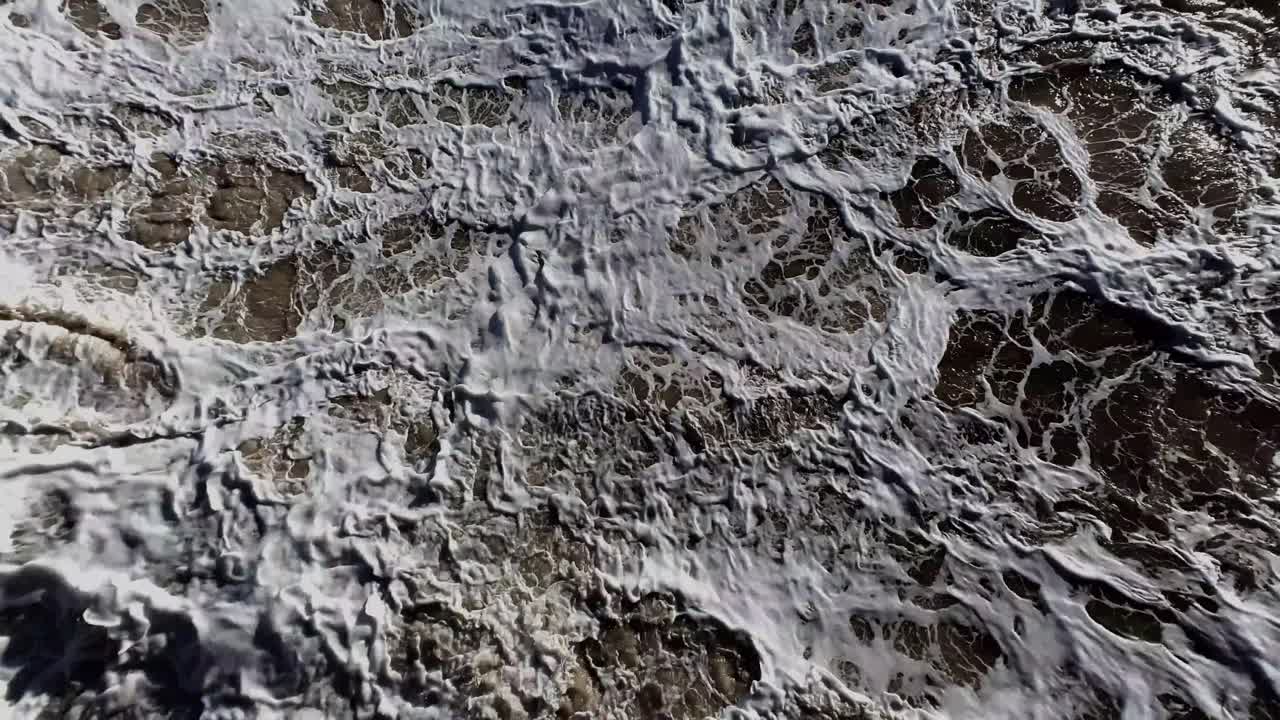 Look down on stormy seas. Graphic abstract shot of the surf crashing violently.