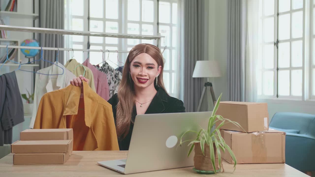 Young Asian Transgender Woman Selling Clothes Online By Live Streaming, Looking And Smiling To Camera. Selling It Online Live Streaming Concept