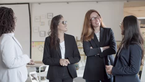 mujeres de negocios profesionales sonrientes hablando en la oficina