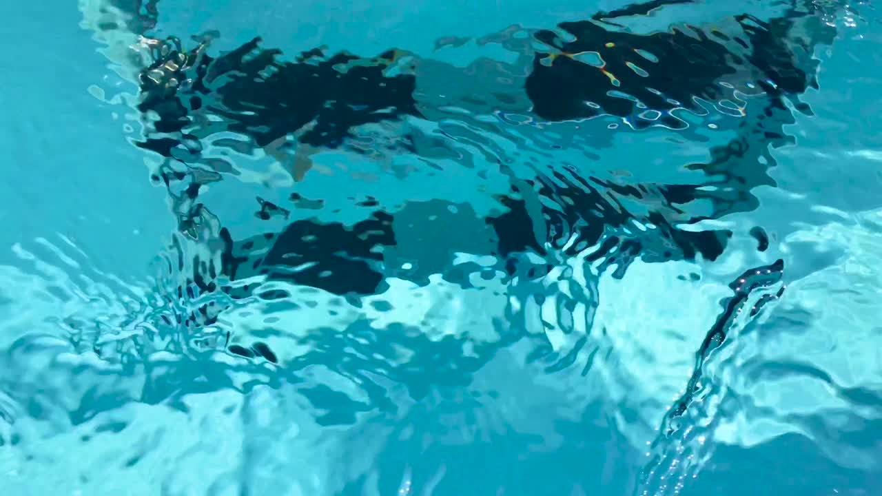 Transparent closeup view of swimming pool ladders with black steps under pellucid crystal clear purified water flowing downstream in 4k