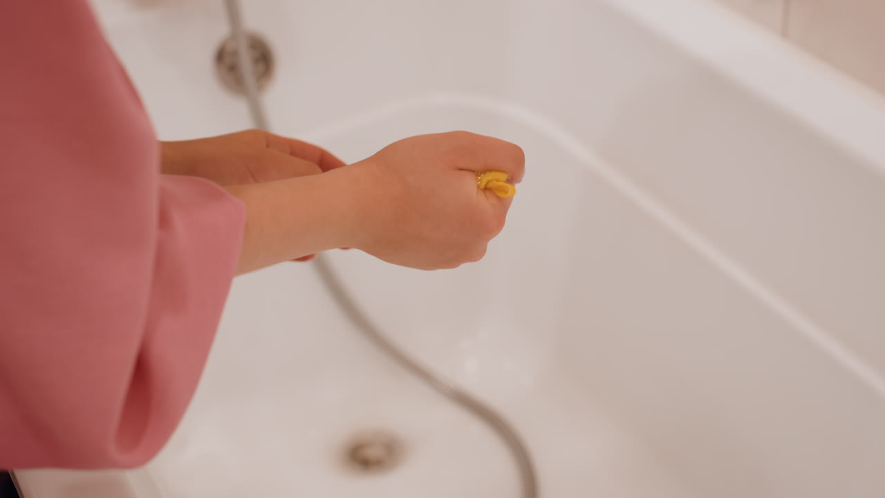 Final Step In Sponge Cleaning Routine, Refreshing Bathroom Routine Involving Sponge Rinsing And Squeezing, Thoroughly Rinsing And Squeezing Sponge As Part Of Cleaning Bathroom Routine