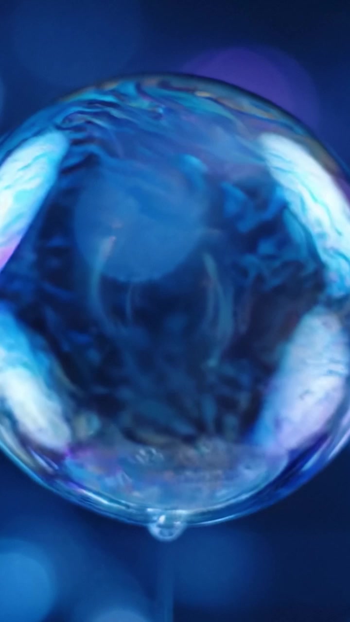 Affascinante viaggio di bolle colorate: un'esplorazione delle superfici riflettenti e delle complessità della luce in un ambiente con sfondo blu