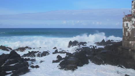 Eine-Große-Welle-Des-Atlantiks-Bricht-An-Einem-Sonnigen-Tag-Während-Eines-Sturms-In-Puerto-De-La-Cruz-Auf-Den-Kanarien-An-Einer-Felsigen-Küste,-Breite-Handaufnahme