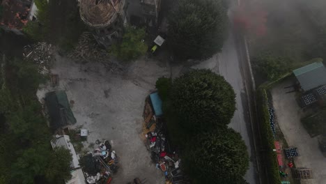 Aerial-top-down-forward-over-Caramulo-Sanatorium-old-abandoned-building-shrouded-in-fog