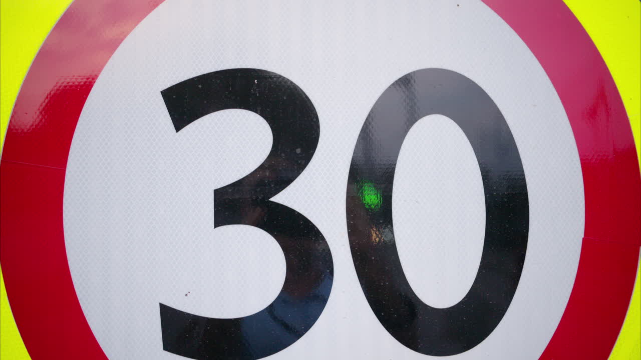 Close view of a 30 km/h maximum speed limit sign on a street