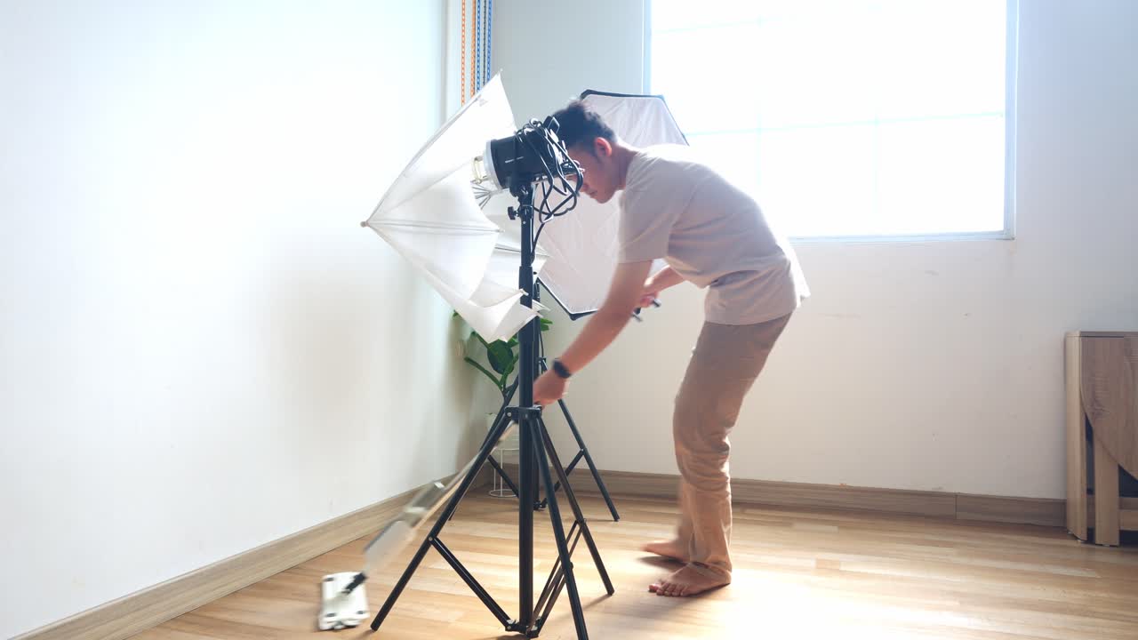 Ung fotograf mopper for at forberede settet til et fotoshoot