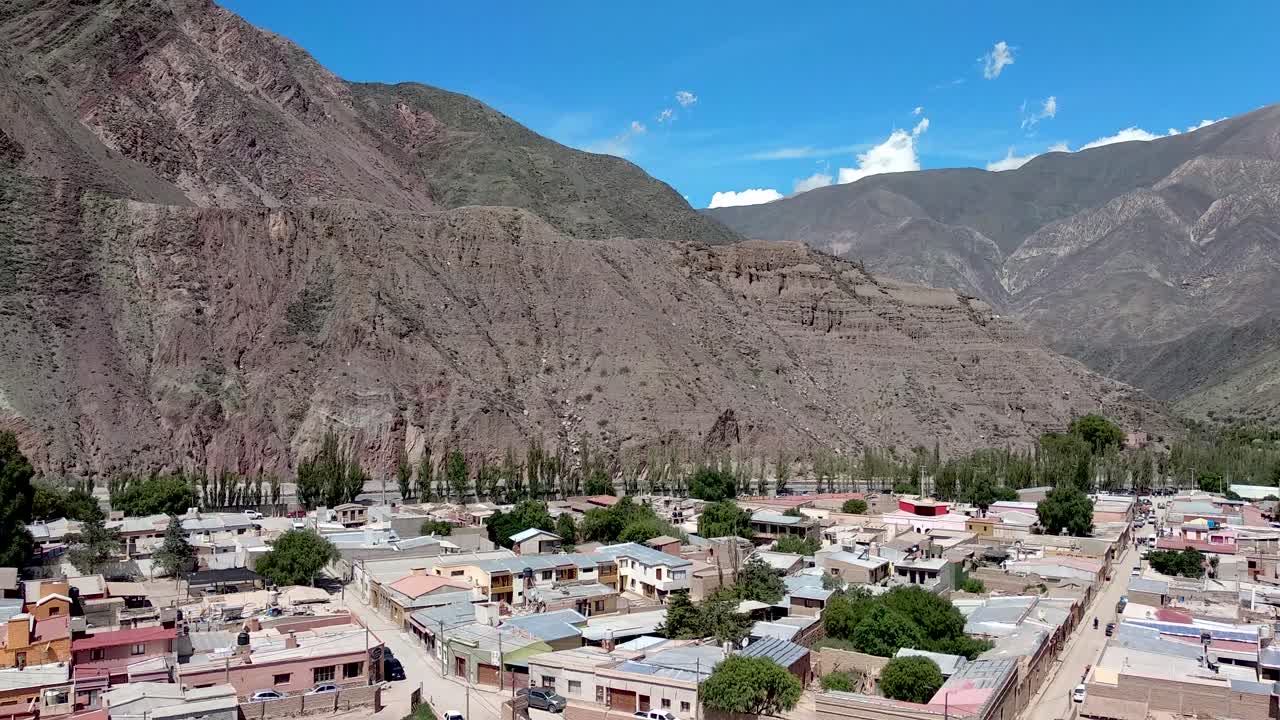 una joven toma una foto con vistas a la ciudad turística de purmamarca, argentina