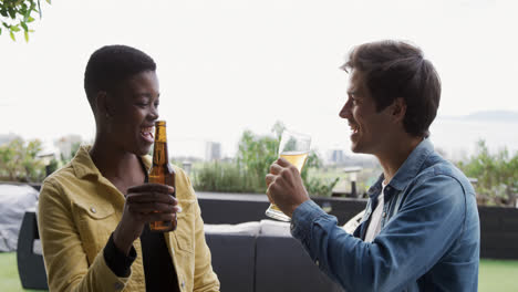 two friends drinking a beer and discussing on a rooftop