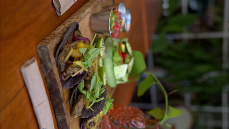 cámara lenta vertical de primer plano de tacos de carne mexicana hechos en yucatán usando especias tradicionales llamadas recaudo en tortillas de maíz azul y cebolla roja