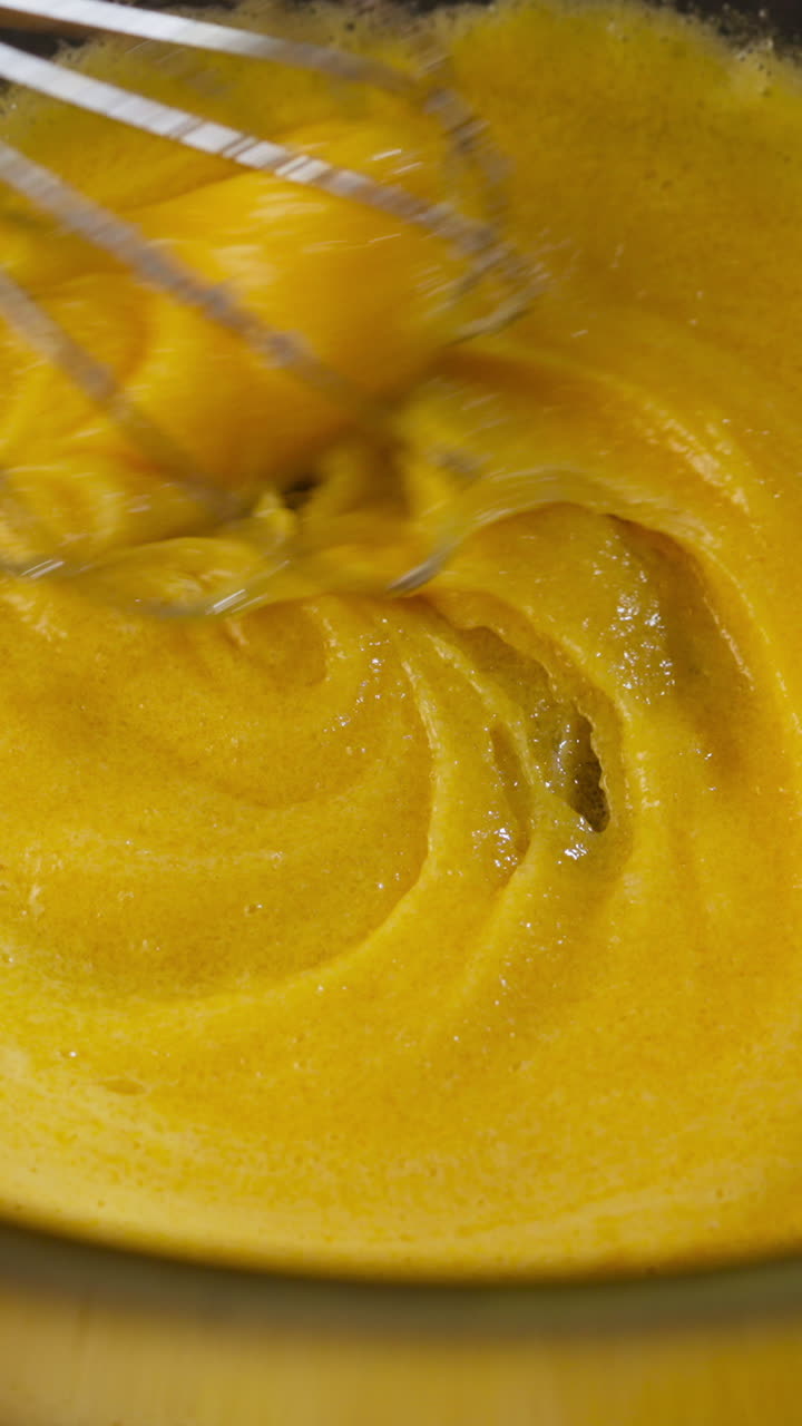 Adding Sugar While Whisking Egg Yolks For Tiramisu Recipe. close-up, vertical shot