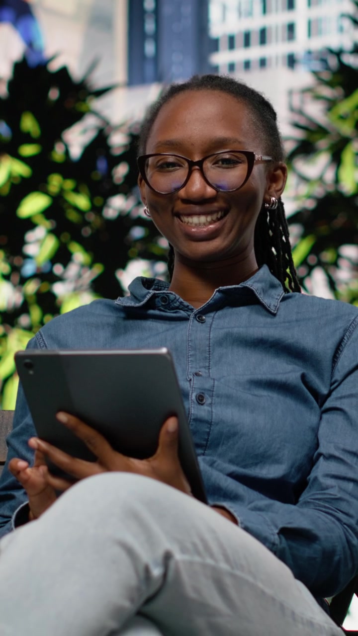 Vertical Video African american freelancer outside using tablet on park bench