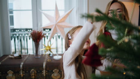 tender woman giving xmas toy girl indoors closeup. mom decorating with daughter