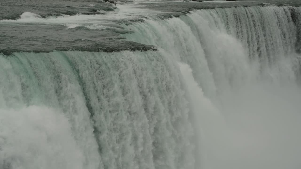 A powerful close-up of Niagara’s Horseshoe Falls as water crashes over the curved cliffside into the misty depths below