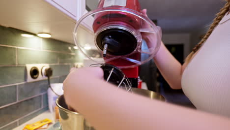 home cook attempts to place whisk attachment on electric kitchen mixer