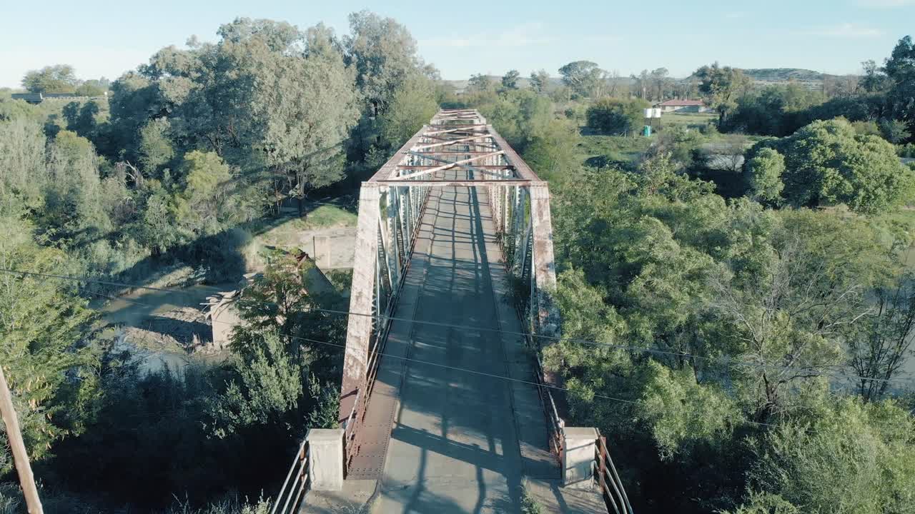여름날 푸른 나무와 푸른 들판에 오래된 녹슨 다리의 공중탄