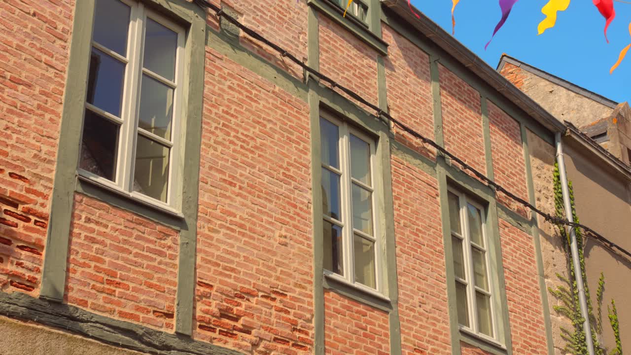 Historic architecture in France is beautifully showcased with colorful flags fluttering in the breeze.