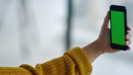 Woman-hands-holding-mobile-phone-with-greenscreen.-Girl-posing-for-selfie