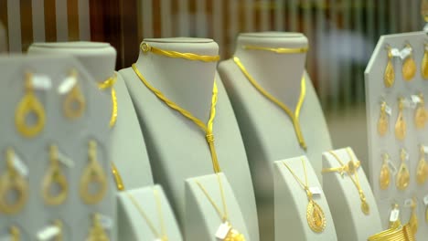 gold necklaces and gold pendants on jewelry stands