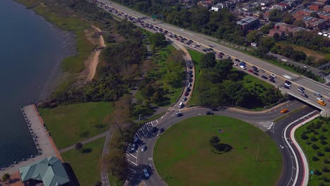 Un-Lapso-De-Tiempo-Aéreo-Del-Intenso-Tráfico-En-Belt-Parkway-Y-Las-Costas-De-La-Bahía-De-Jamaica-En-Un-Día-Soleado-En-Brooklyn,-Nueva-York