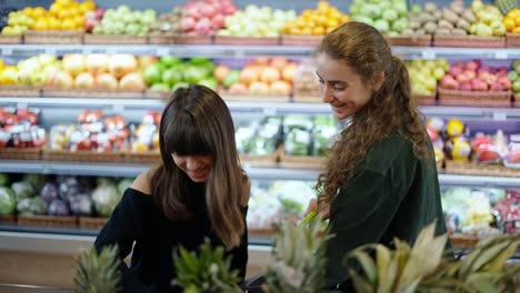 Dos-Chicas-Caucásicas-Eligiendo-Biofrutas---Uva-En-El-Supermercado-Juntas