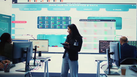 gerente de la empresa que examina las actualizaciones y detalles del proyecto en la sala de monitoreo
