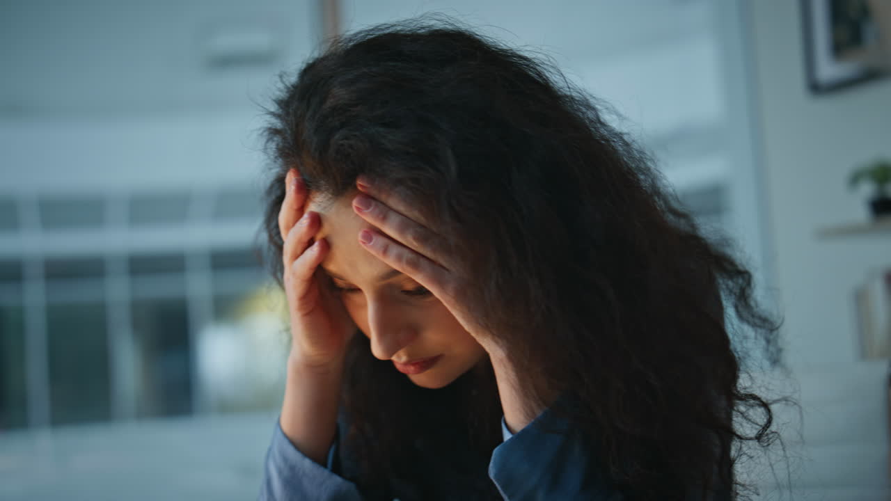 Stressed woman holding face in office closeup. Frustrated lady thinking problems