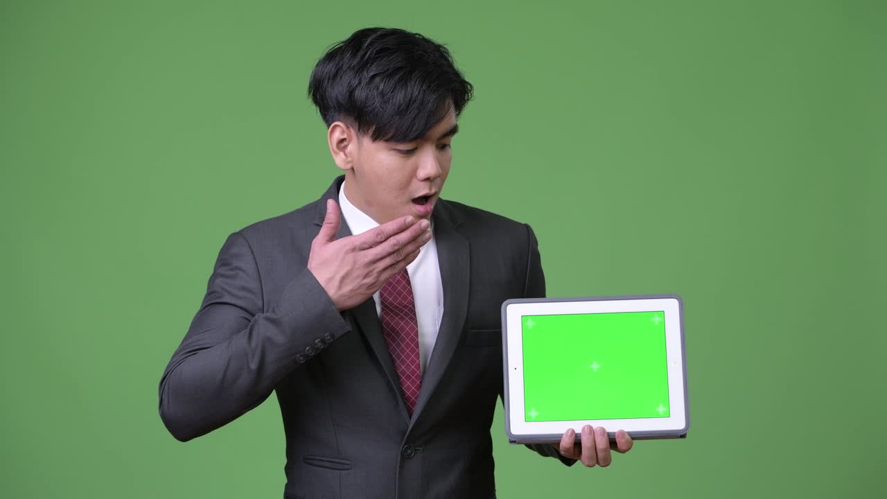 디지털 태블릿을 사용하는 젊은 잘생긴 아시아 사업가