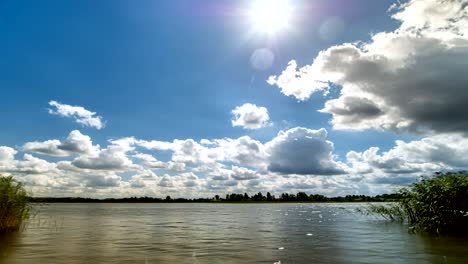 white clouds on blue sky over lake time lapse
