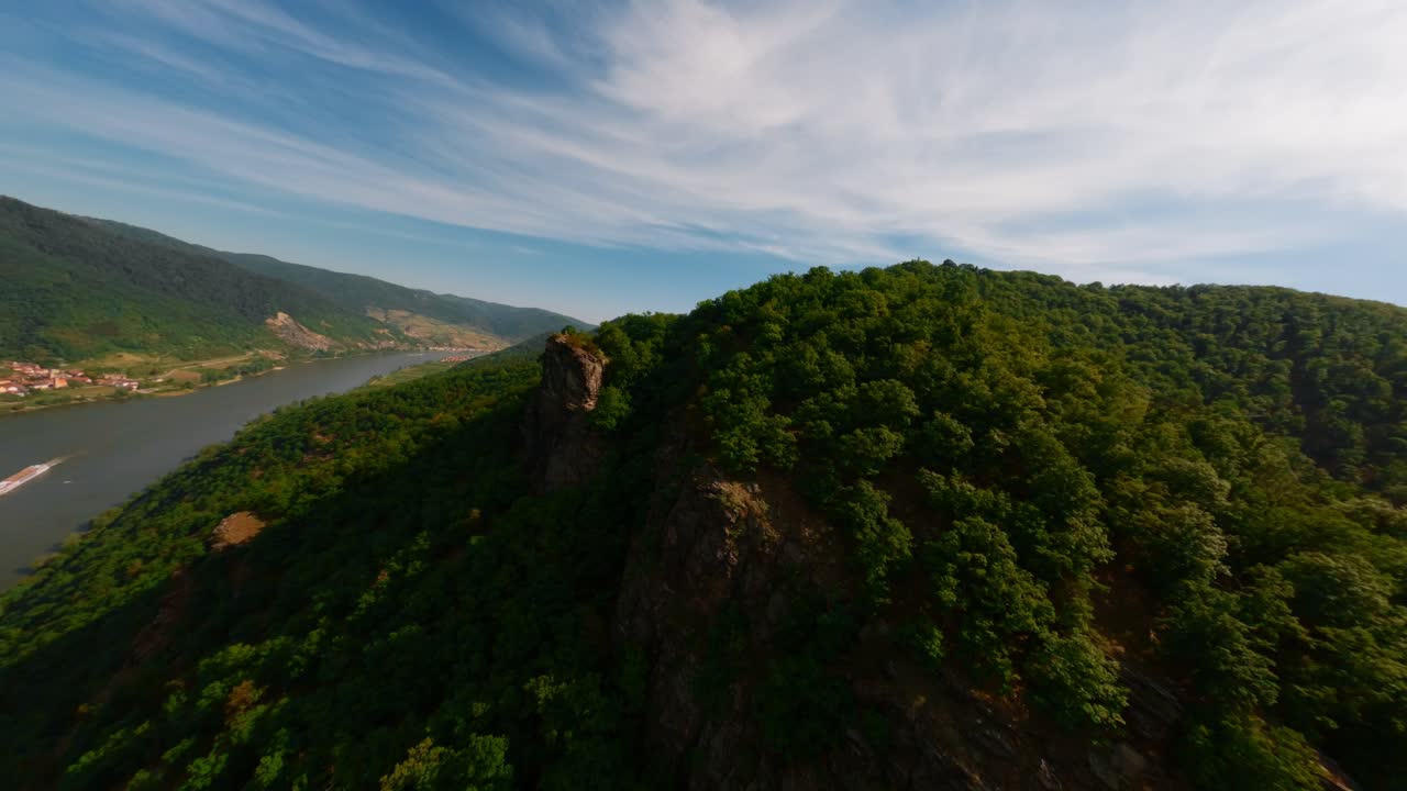 fpv volando sobre la cima de la montaña hasta el valle afilado de wachau que revela el infinito río danubio, tischwand