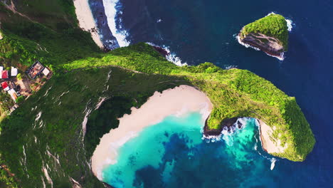 inaccessible tropical beach below steep cape cliffs with green foliage