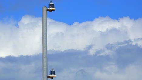 fast moving layered clouds with derelict metal post in foreground