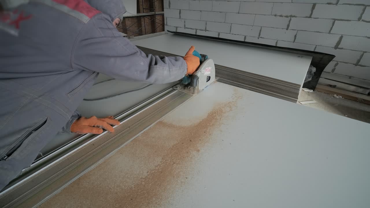 Male hands measuring and cutting gypsum plasterboard