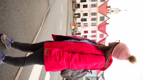 Woman-with-jacket-and-glasses-looking-around-pier-area-of-Torshavn,-Faroe-Islands