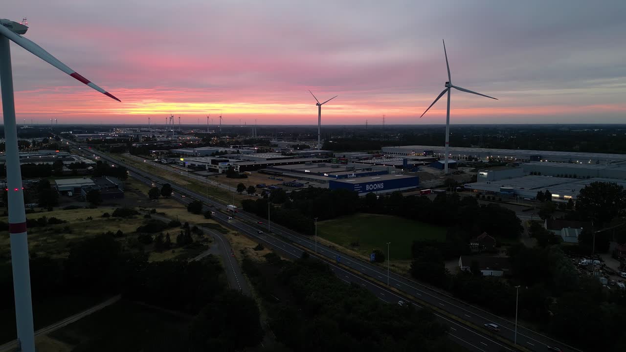 majestuoso cielo al atardecer y silueta de turbinas eólicas, carretera y área urbana, vista aérea