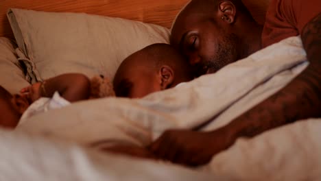 family with single father and sons sleeping in bed together