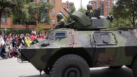green camouflage m1117 with soldiers saluting. colombian army military parade. independence day, july 20th