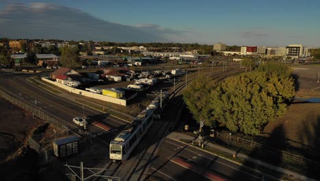 a light rail train zooms by as the sunset covers the landscape