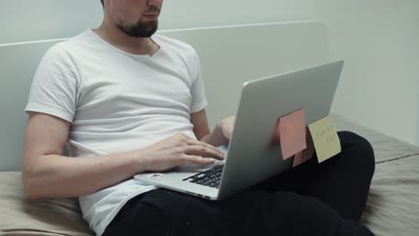 hombre trabajando en la computadora portátil en la cama
