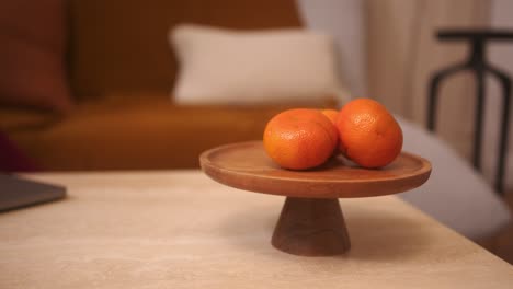 oranges on a wooden stand on a coffee table in a warm cozy home