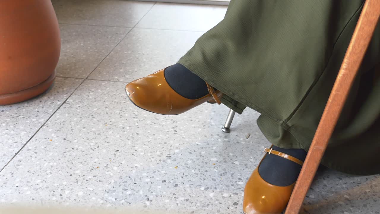 Woman Sitting with Brown Shoes and Green Pants