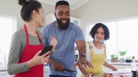 Smiling-diverse-female-and-male-friends-cooking-and-talking-in-kitchen,-in-slow-motion