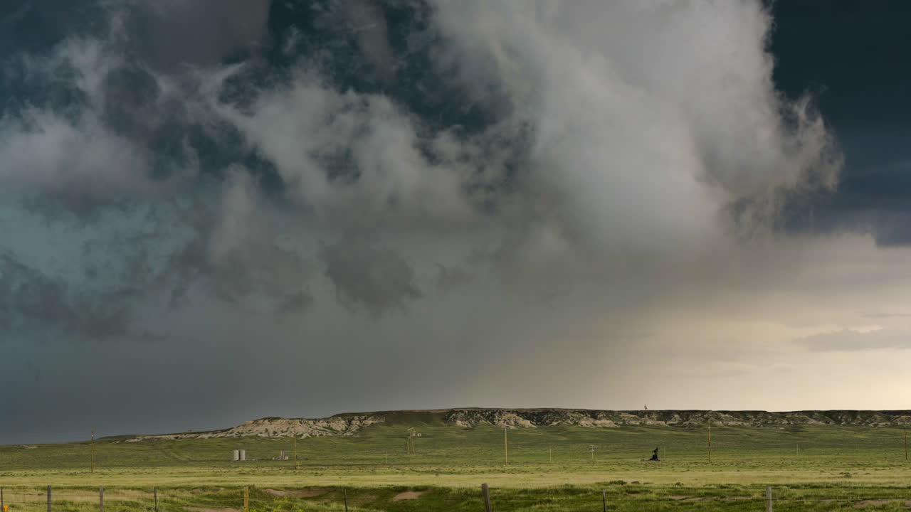 Watching dark storm clouds roll in over green grasslands