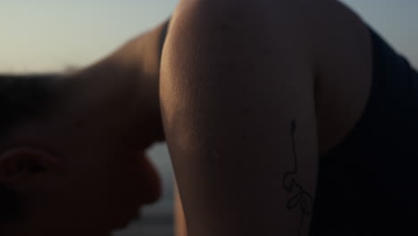 Closeup-girl-making-worm-up-in-front-calm-ocean-close-up.-Woman-training-yoga.