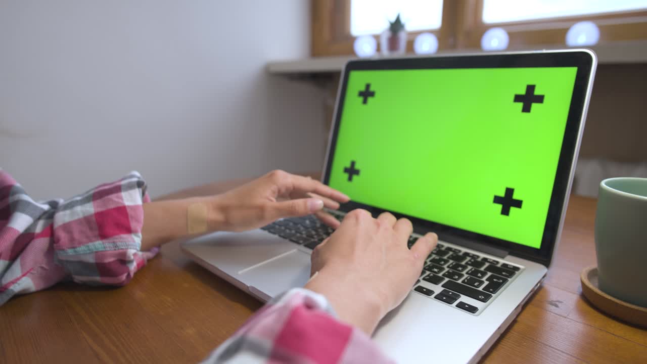 mujer usando portátil con pantalla verde. negocio, comunicación, freelance y concepto de internet. trabajando en un portátil en casa