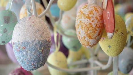 huevos de pascua coloridos decorados y colgados en un árbol