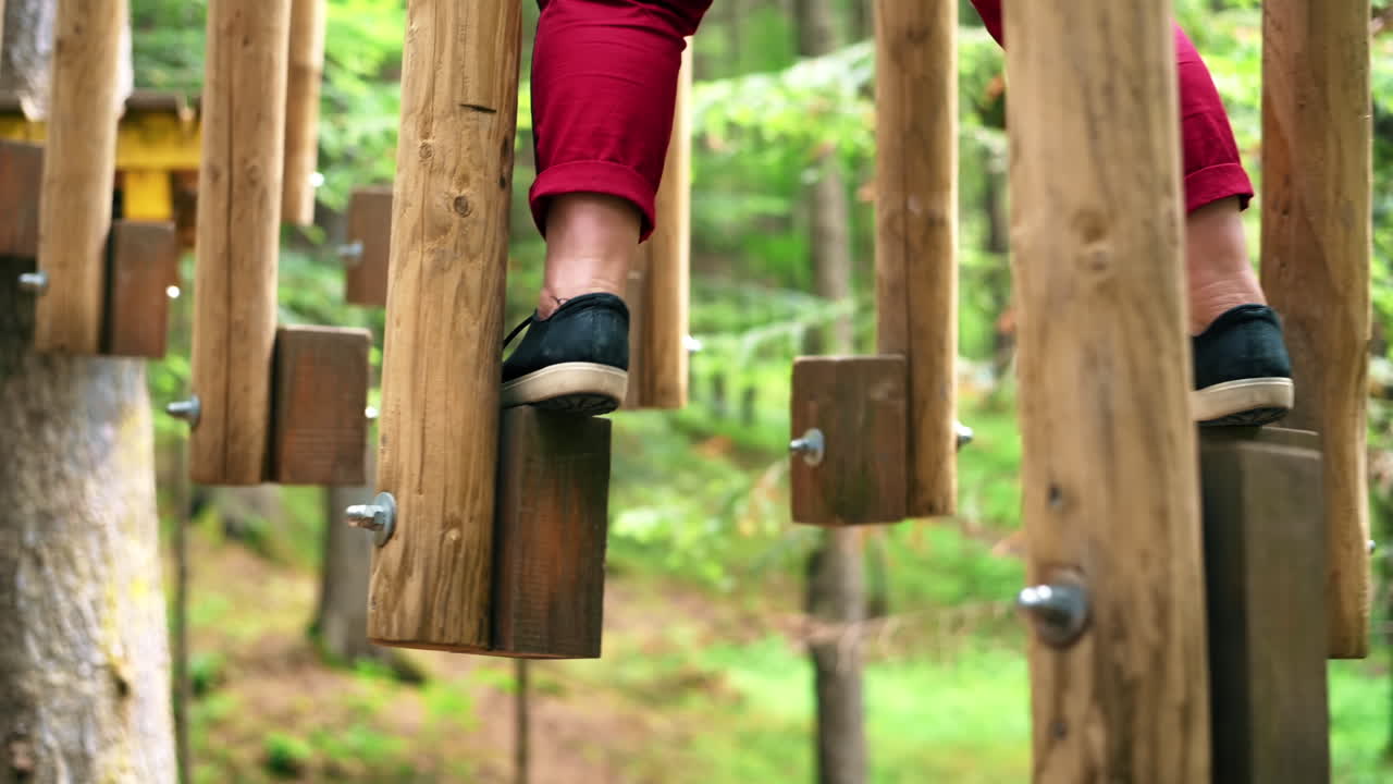 View of a woman at climbing adventure park in the Carpathians, greenery around, Romania
